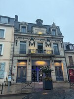 Un edificio histórico con detalles arquitectónicos ornamentales, incluyendo una entrada destacada con un cartel que dice 