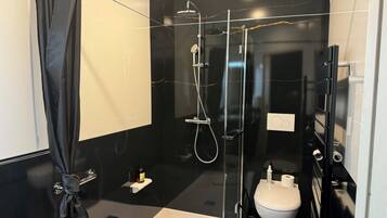 Une salle de bain moderne avec une douche à parois de verre, des toilettes et un lavabo.