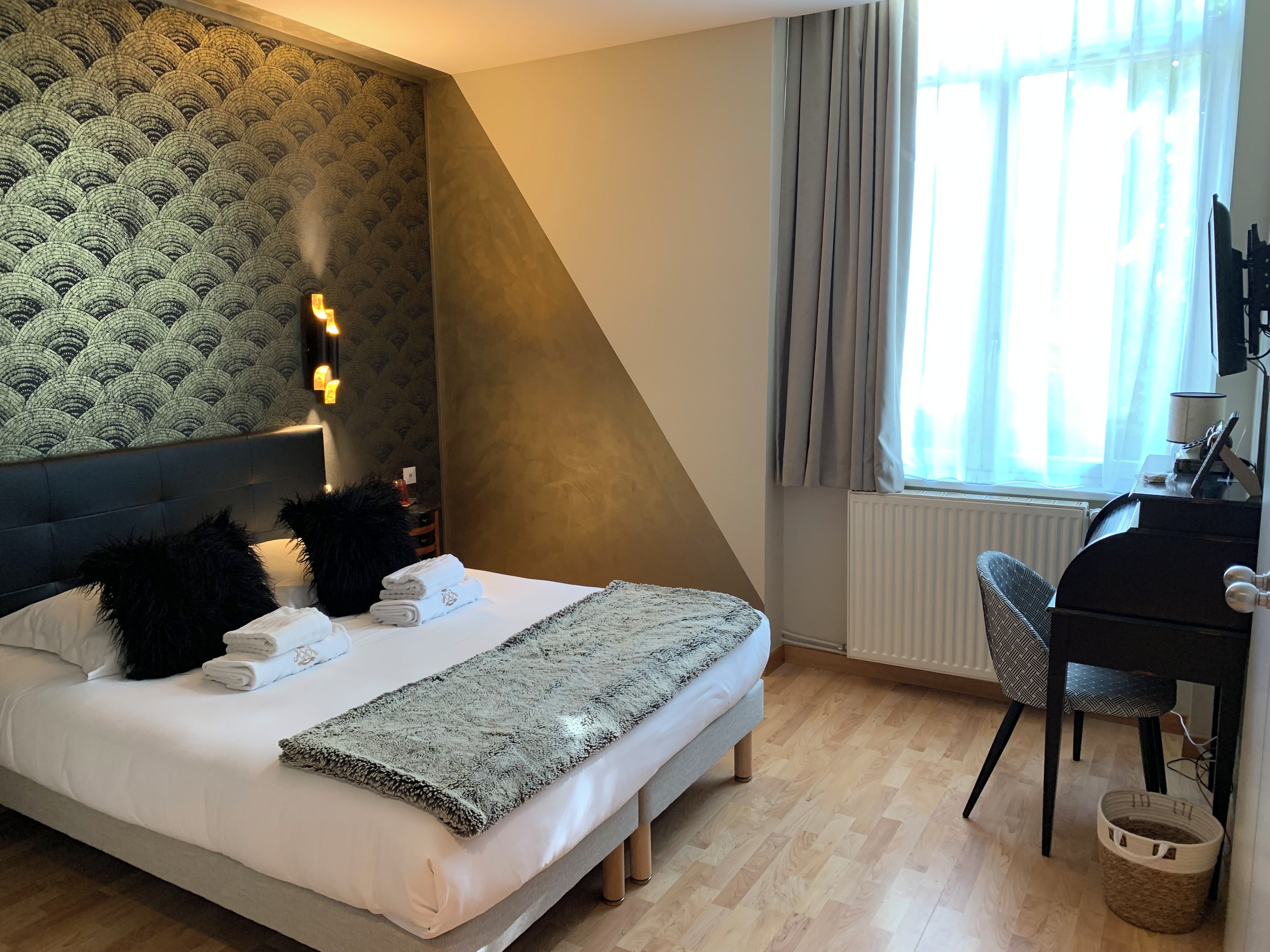 Un dormitorio con una cama, un escritorio y una silla.