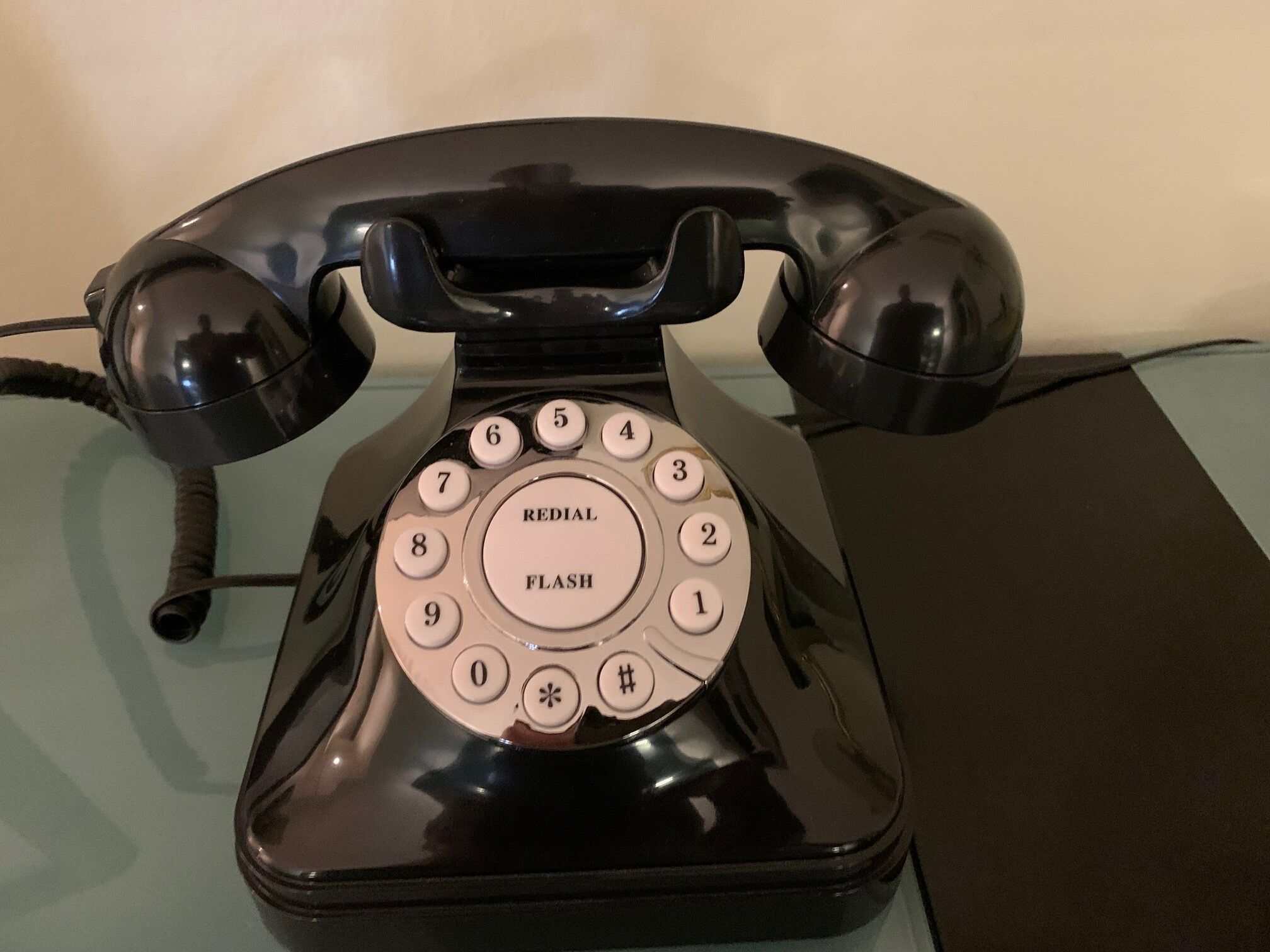 Un teléfono con dial giratorio y botón de rellamada.