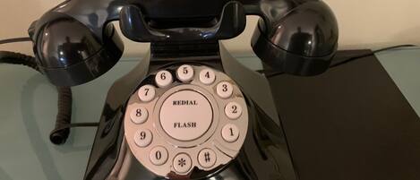 Un teléfono con dial giratorio y botón de rellamada.