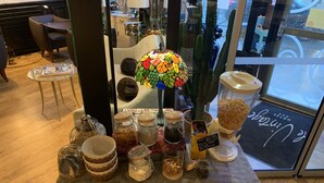 A table with various food items and a cactus centerpiece. - Hôtel Vintage (Quimperle)
