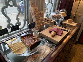 Una vitrina de panadería con diversos productos horneados, incluyendo pan, pasteles y un pastel.