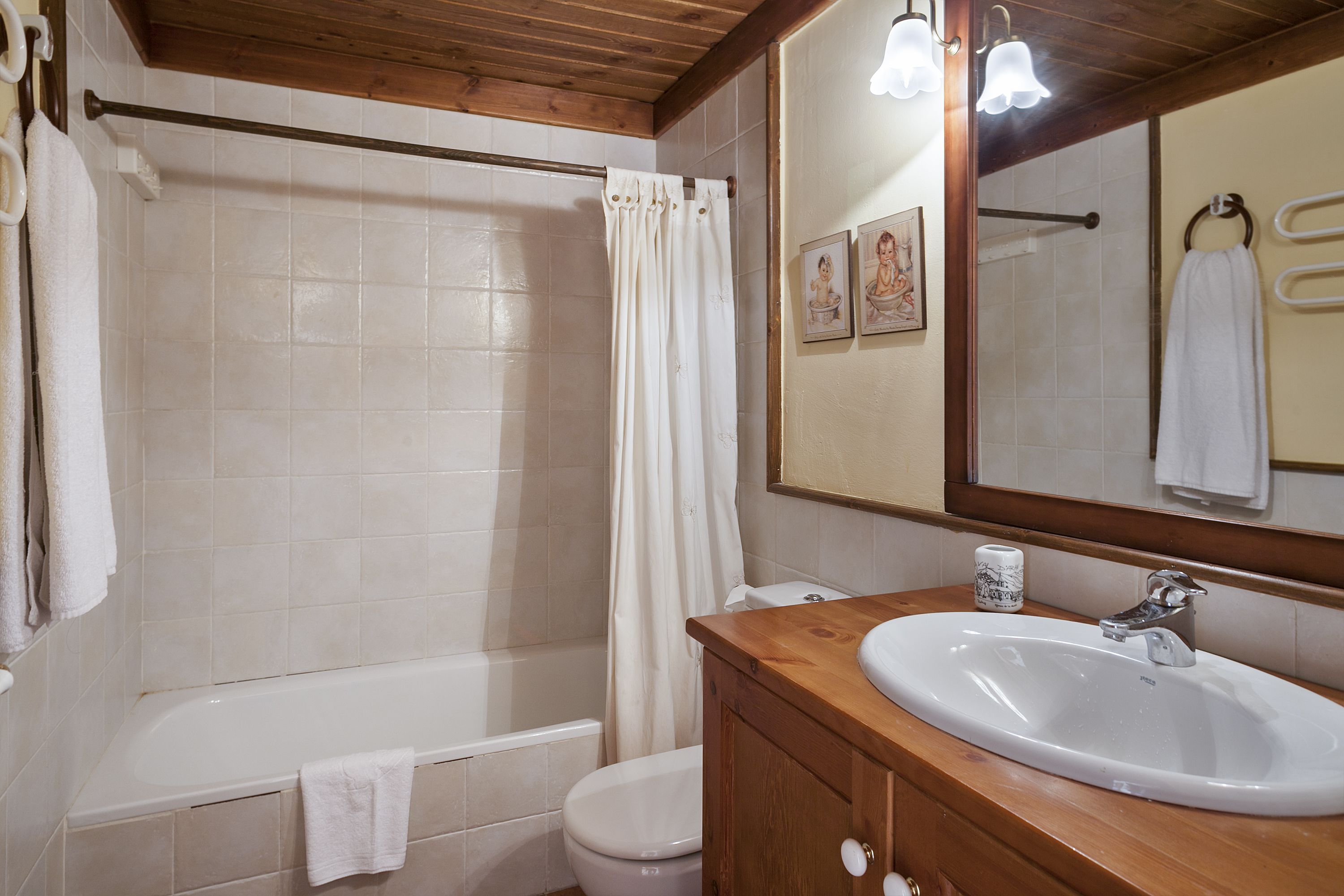A bathroom with a bathtub, toilet, sink, and a mirror.