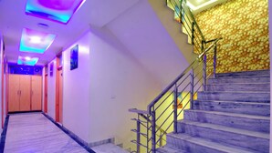 A modern interior with a marble staircase, a wooden door, and a patterned wall. - Check In Room Main Bazar (New Delhi)