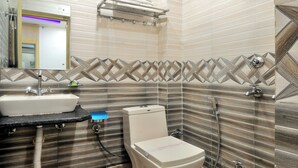 A bathroom with a sink, toilet, and shower. - Check In Room Main Bazar (New Delhi)