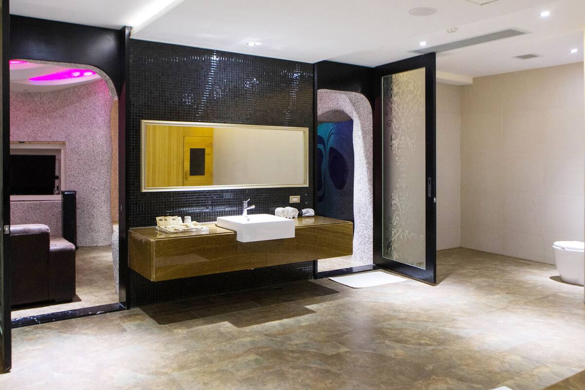 Ein modernes Badezimmer mit einem großen Spiegel, zwei Waschbecken und einem Waschtisch.