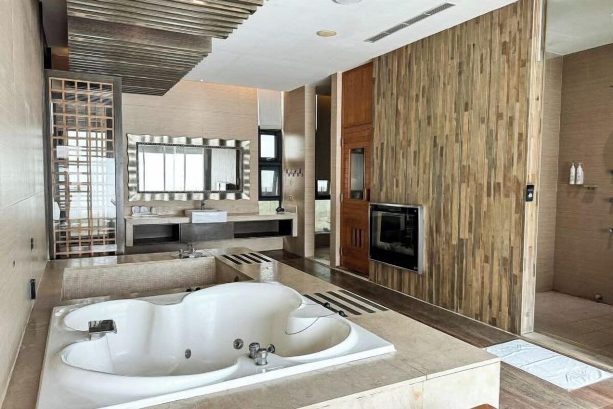 Un bagno moderno con una vasca da bagno ampia, un mobile vanità con specchio e una zona doccia.