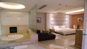 A modern hotel room with a large bathtub, a separate bedroom with a bed and nightstands, and a wooden cabinet. - All-Ur Boutique Motel - Chang-Hua Branch (Changhua)