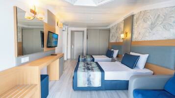 A modern hotel room with a large bed, a desk, a TV, and a large mirror.