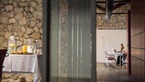 A dining area with a stone wall and a table set with breakfast items. - Confluent Health Resort (Cofrentes)