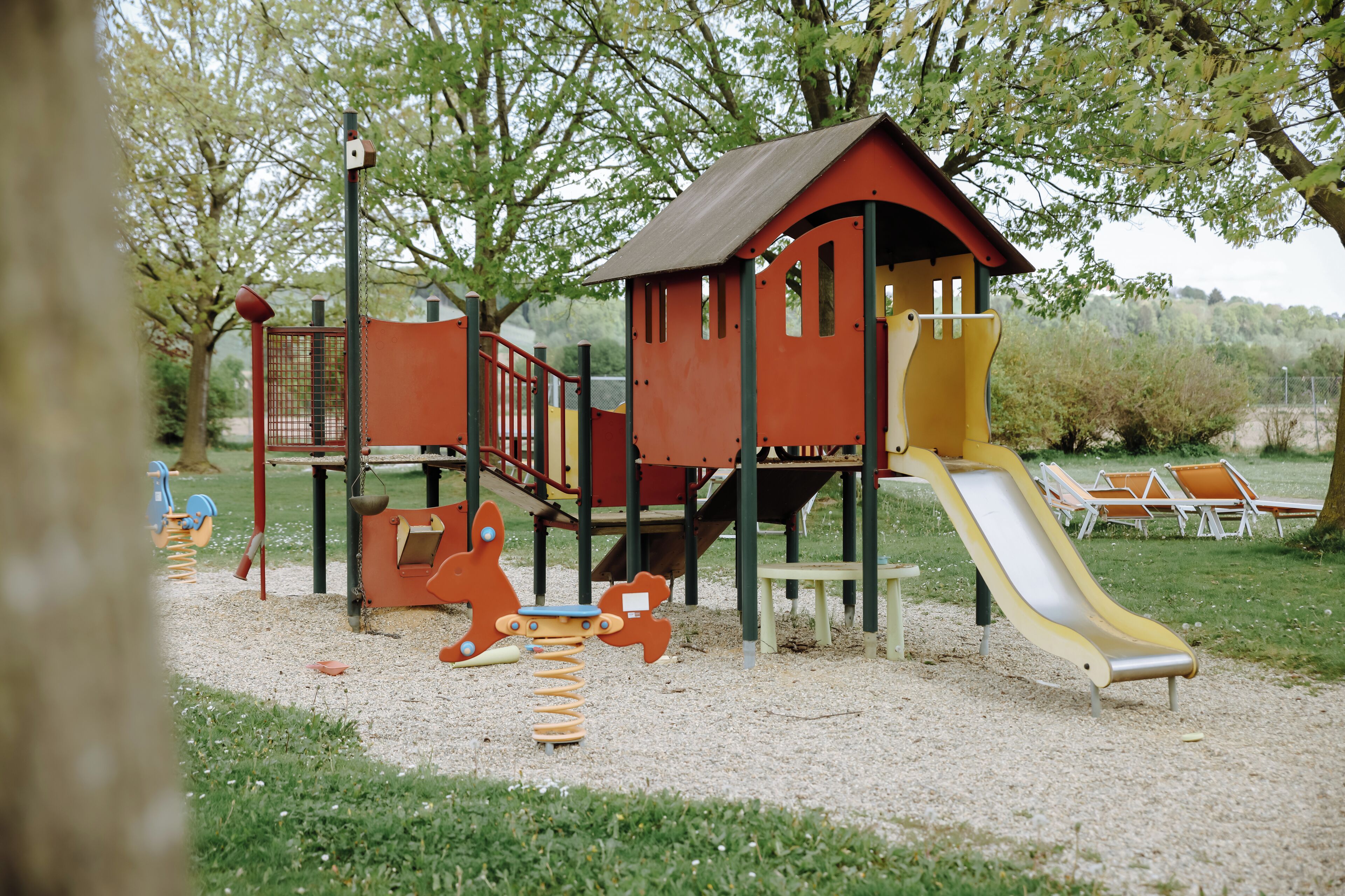 Un parque infantil con tobogán, estructuras de escalada y columpios.