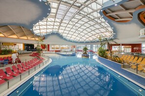 An indoor swimming pool with a high ceiling and a glass dome structure. - H2O Hotel-Therme-Resort (Bad Waltersdorf)