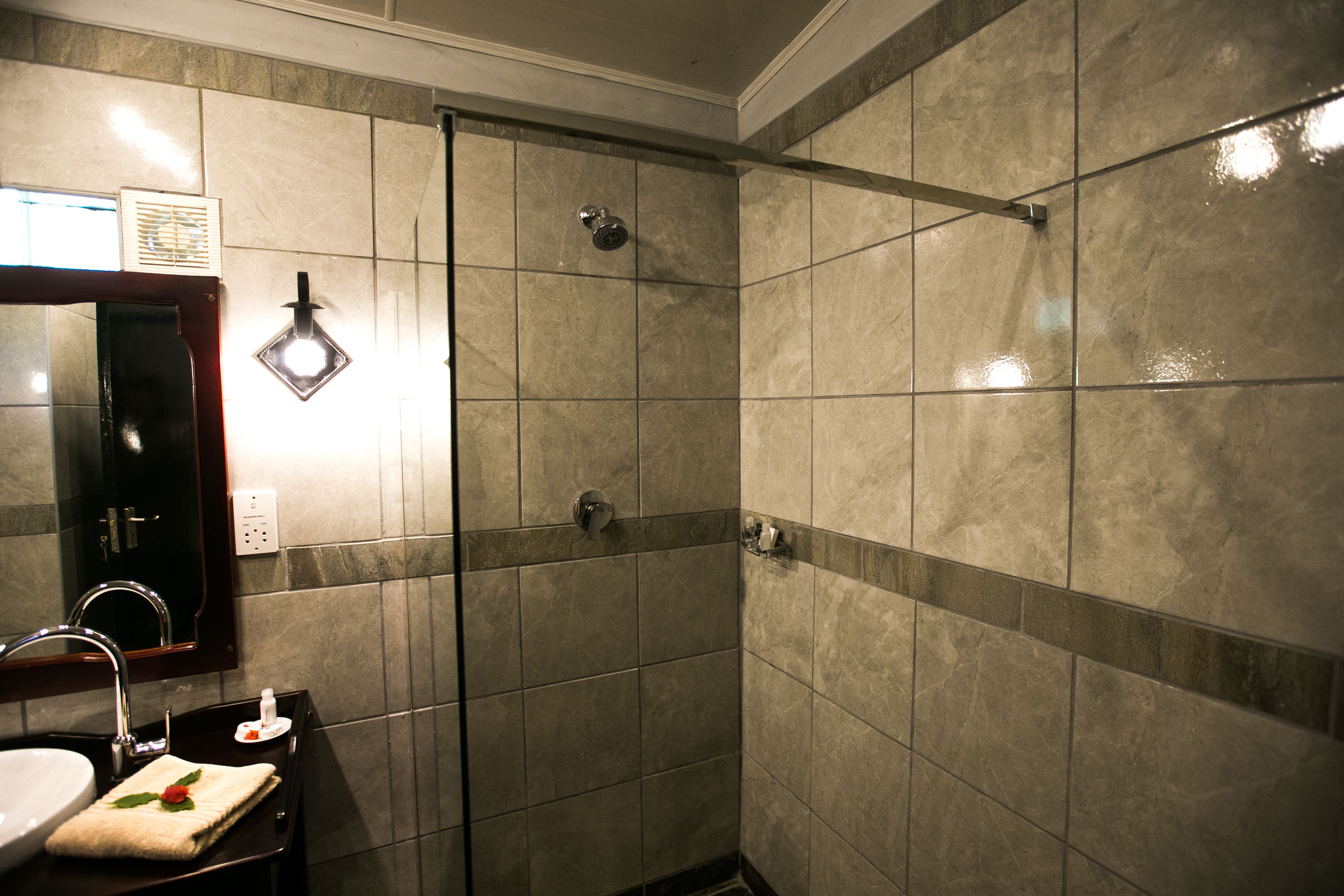 Une salle de bain avec un lavabo, un miroir et une douche.