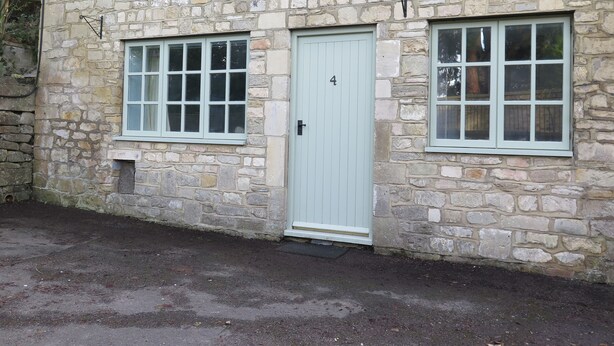 A stone building with a light blue door and two windows, labeled with the number 4. - The Lodge (Corsham)