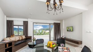 Un salón moderno con una mesa de comedor de vidrio, asientos cómodos y vistas al exterior.