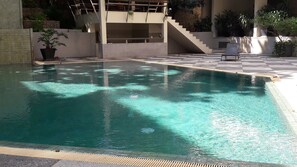 A swimming pool with a tiled deck, a staircase, and potted plants. - The Green Golf Residence Condominium (Kathu)