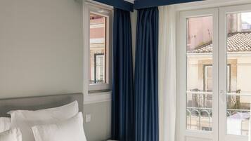A hotel room with a bed, a window, and a view of the outside.