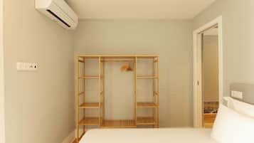 Un dormitorio con cama, armario de madera y aire acondicionado.
