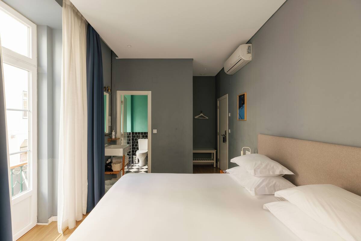 Hotellihuone, jossa on sänky, kylpyhuone ja näkymä ulos.