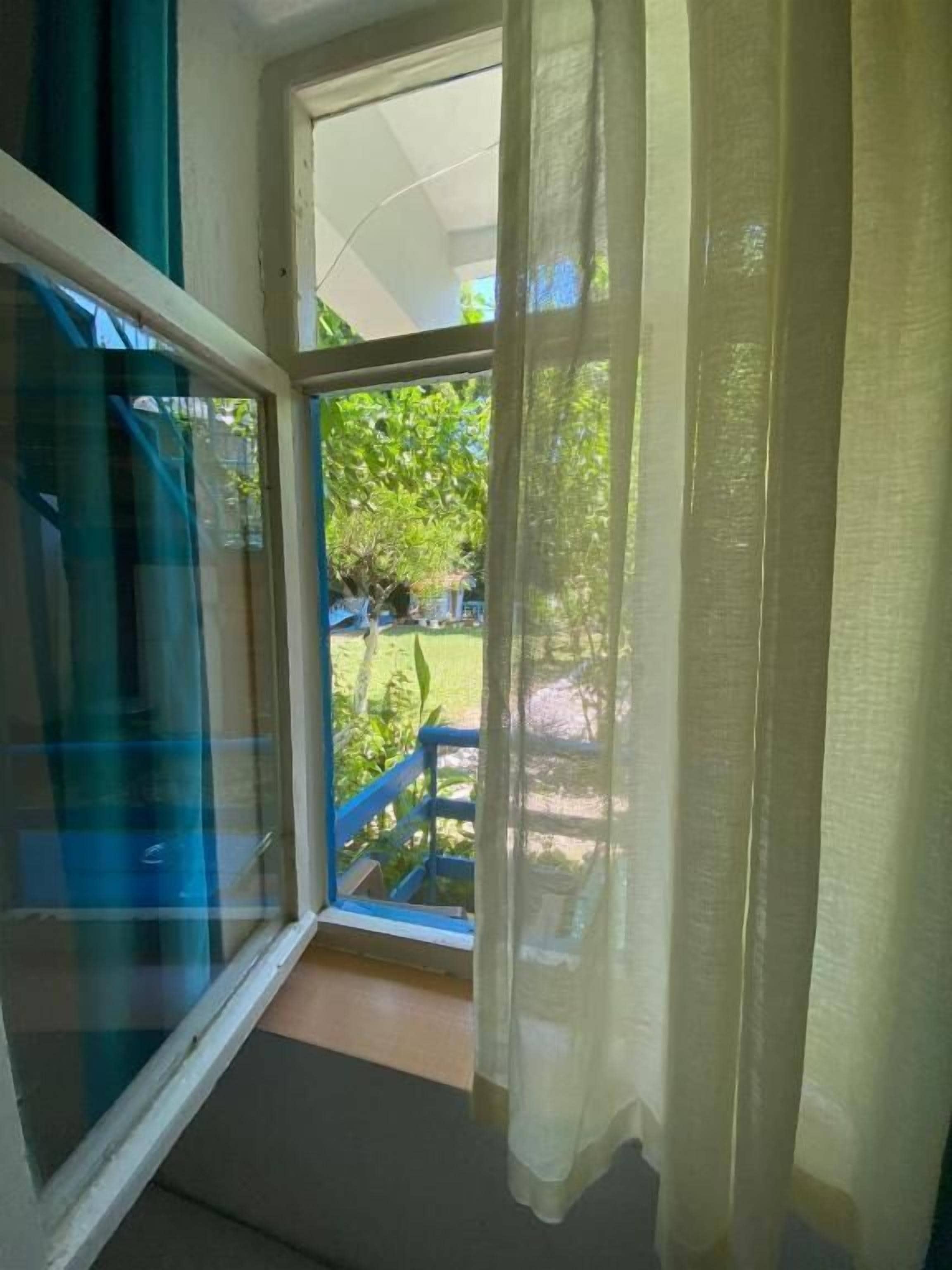 A room with a sliding glass door leading to an outdoor area with a blue railing.