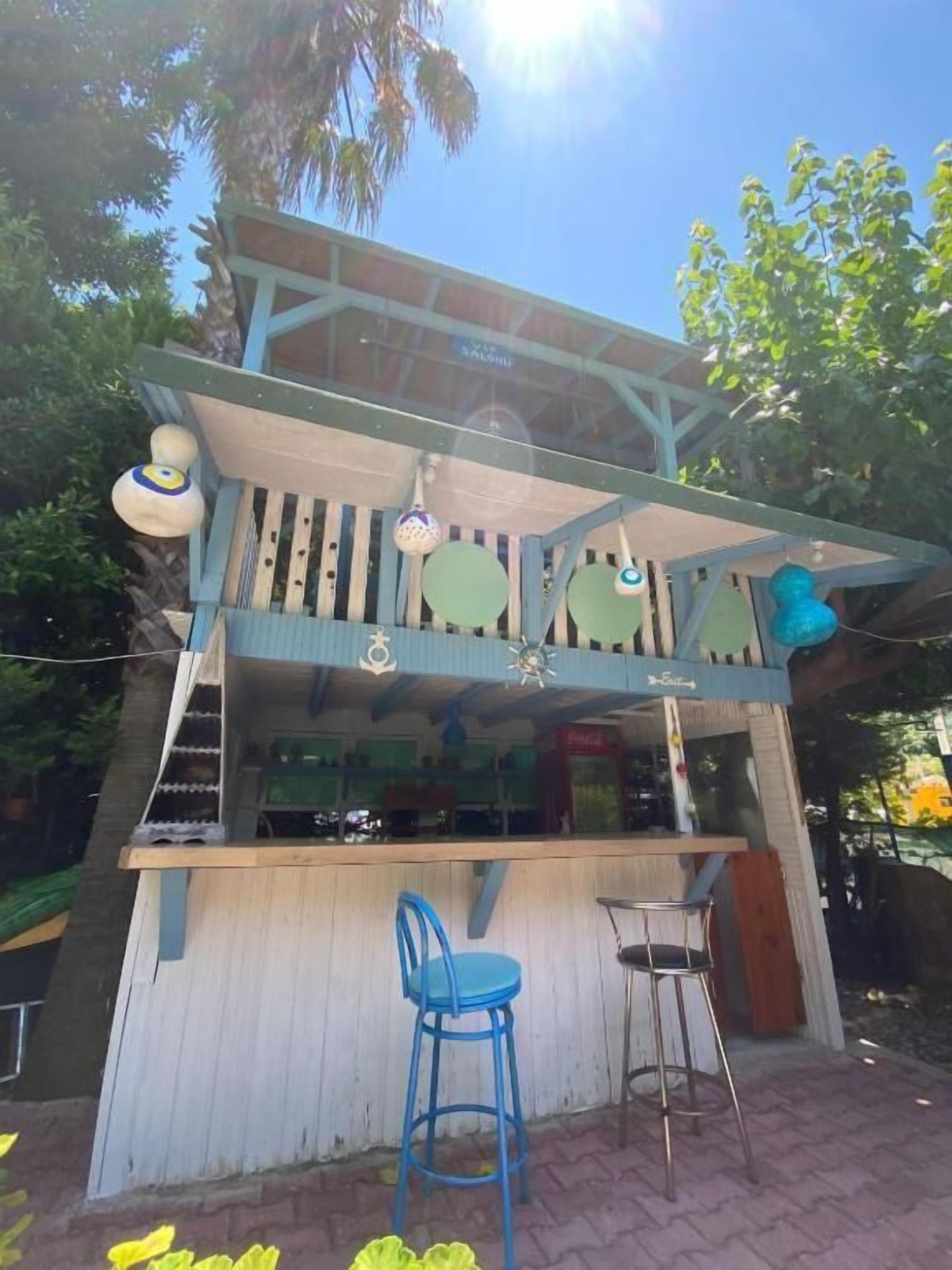 Un bar con mostrador de madera y dos taburetes azules.
