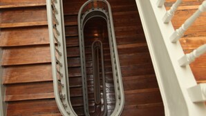 A curved staircase with white balusters and a wooden floor.