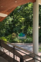 Una escalera conduce a un área techada con un cartel de Lisland Winforest Resort en medio de abundante vegetación.