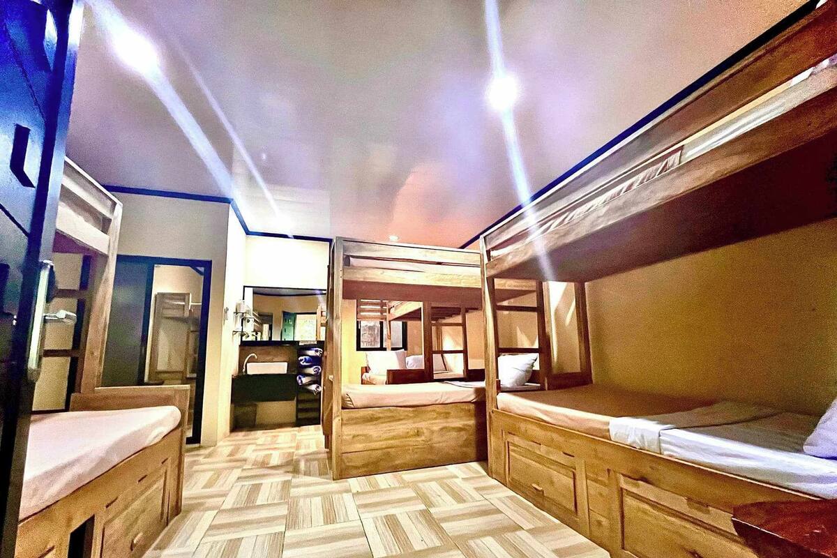 Een ruimtelijk treincabine met houten slaapplekken, een kitchenette en een badkamer.