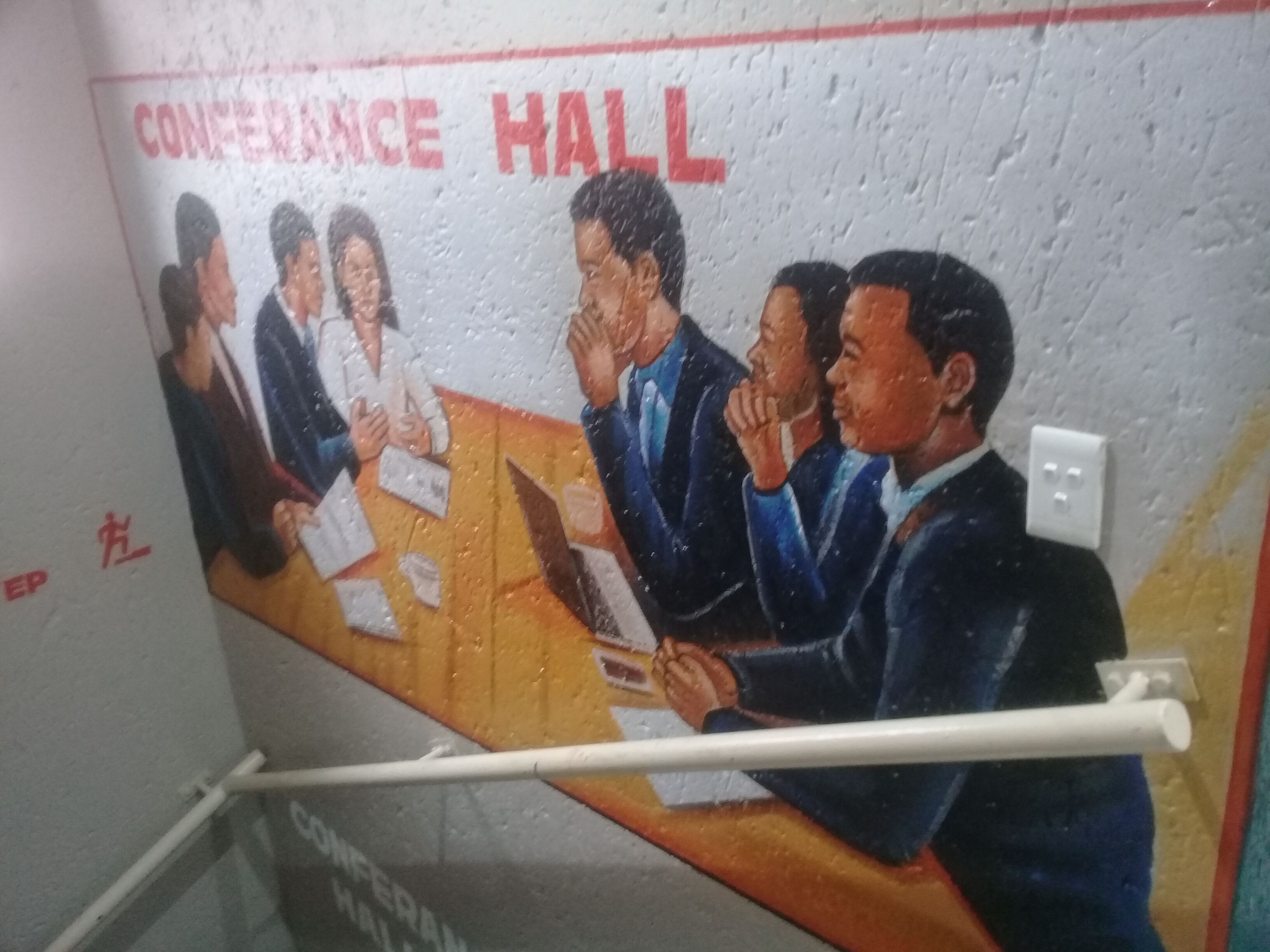 A mural of a conference hall with a group of people seated around a table.