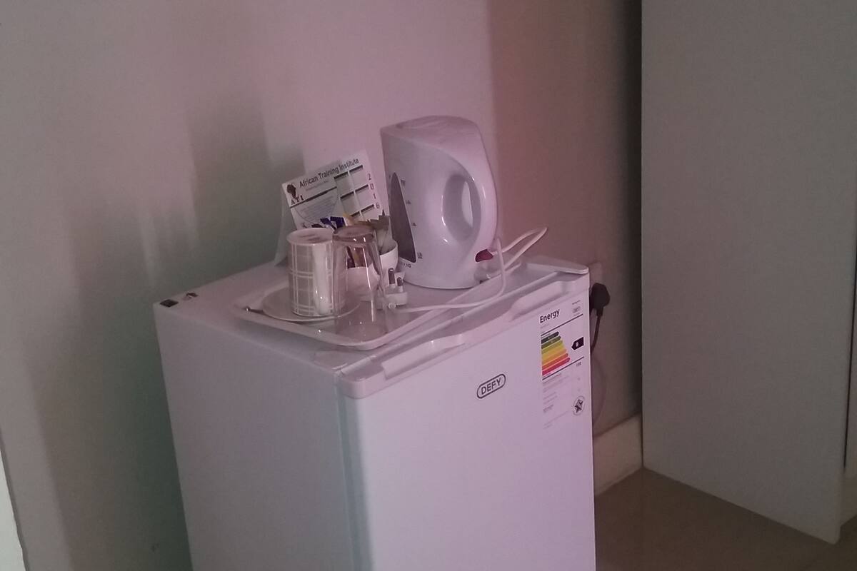 Un réfrigérateur blanc doté d’un distributeur d’eau et d’un petit compartiment congélateur.