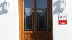 A white building with a wooden double door, a sign above the door reading "SOMERFIELD LODGE", and a red sign with a five-star rating from "Cymru Wales". - Somerfield Lodge (Swansea)