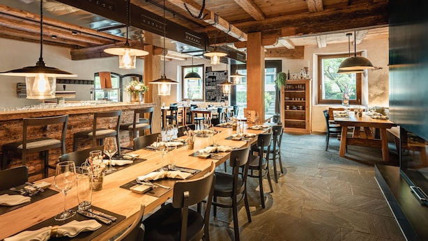 Une cuisine spacieuse dotée d’un long comptoir, de luminaires suspendus et d’une grande fenêtre qui laisse entrer la lumière naturelle.
