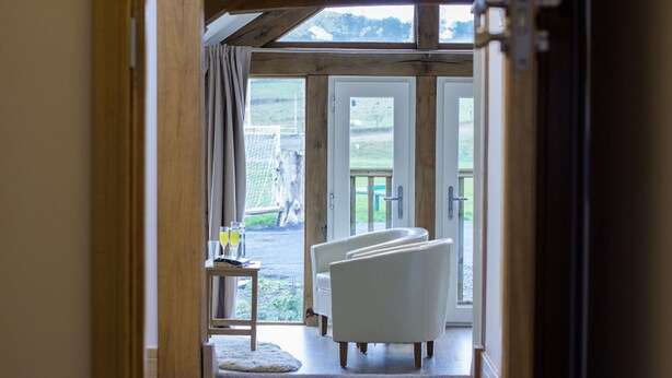 A hallway leading to a seating area with a view of the outdoors. - Tynrhyd Retreat (Aberystwyth)