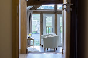 A hallway leading to a seating area with a view of the outdoors.