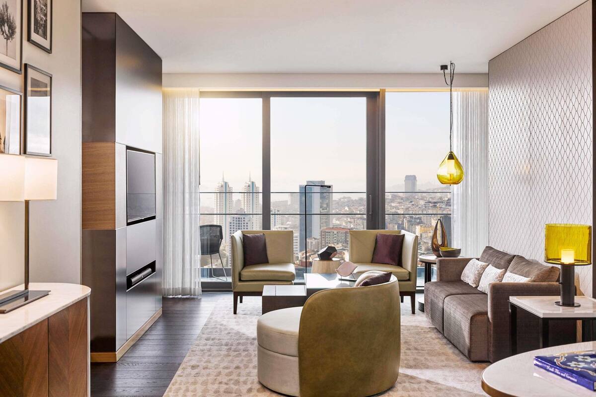 A modern living room with a city view, a sofa set, a coffee table, and a TV.