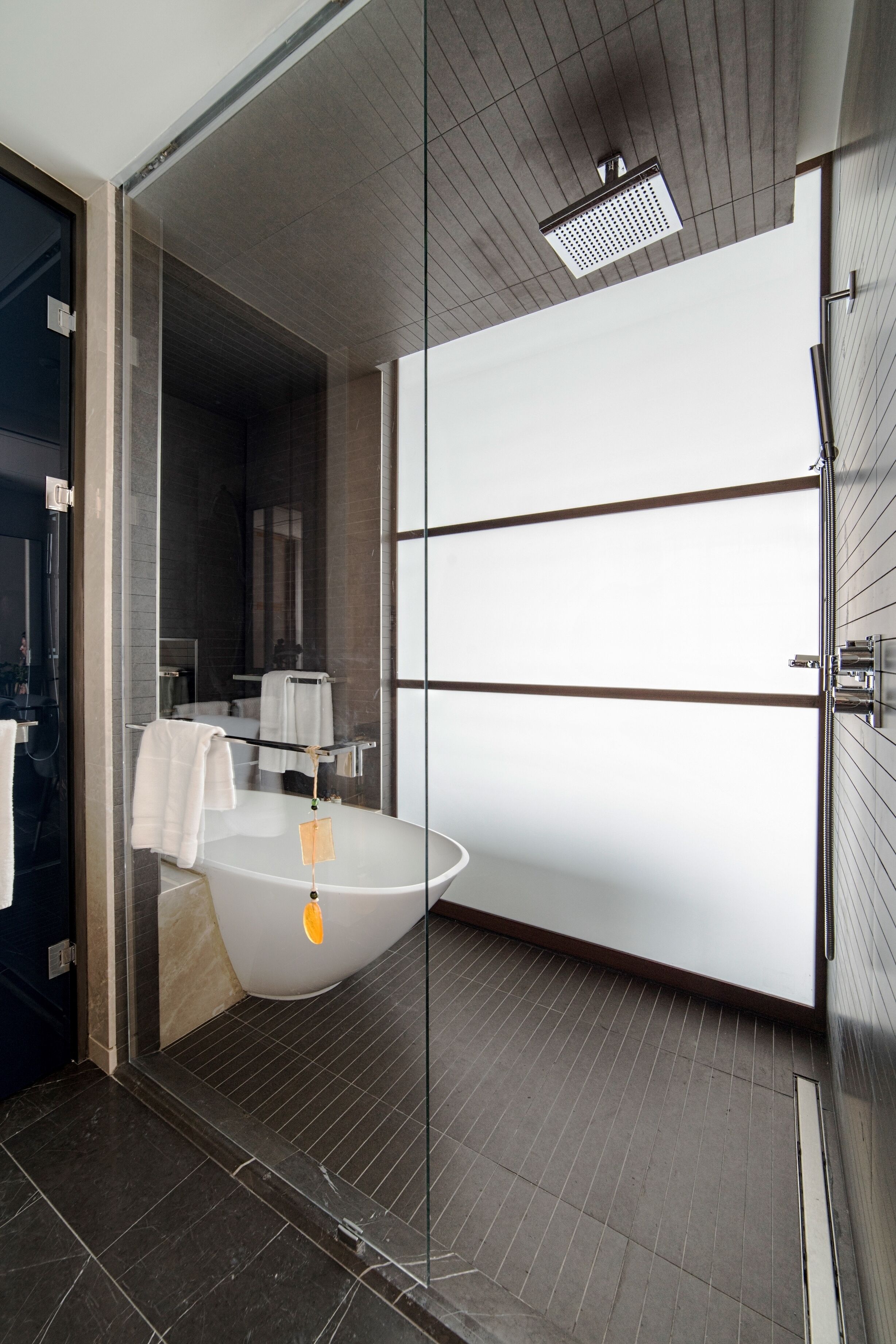 Ein modernes Badezimmer mit freistehender Badewanne, einer Duschkabine aus Glas und einem großen Spiegel.
