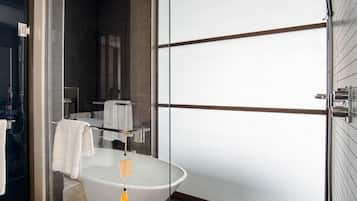 A modern bathroom with a freestanding bathtub, a glass shower enclosure, and a large mirror.
