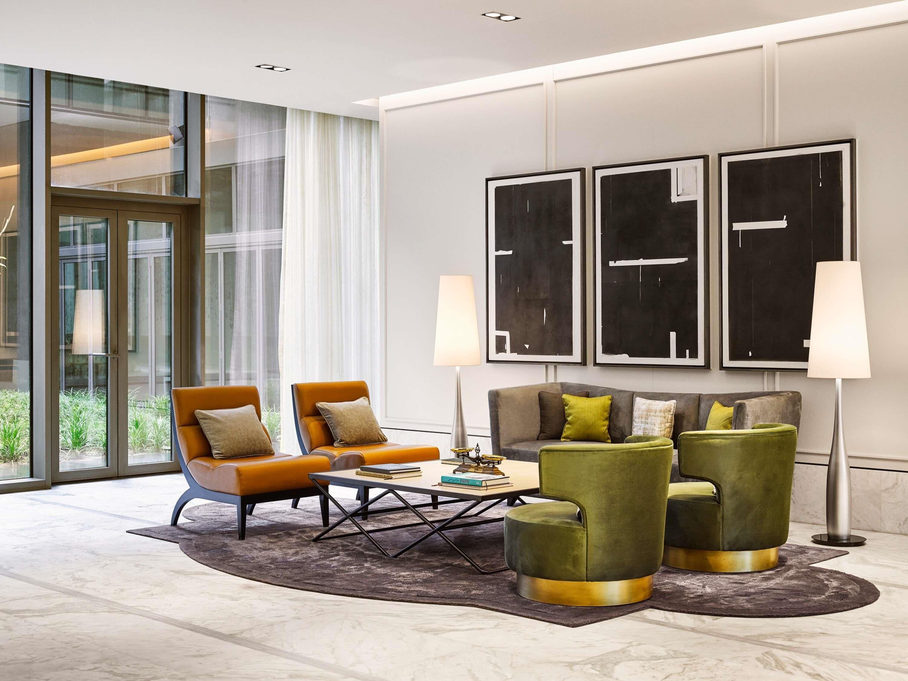 A modern living room with a sofa, armchairs, a coffee table, and artwork on the wall.