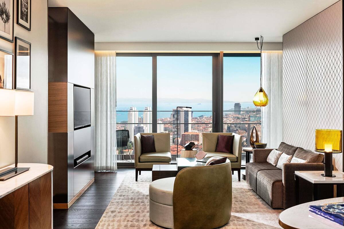 A modern living room with a city view, a sofa, a coffee table, and a TV.