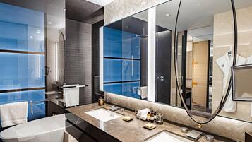 A modern bathroom with two sinks, a large mirror, and a glass shower enclosure.