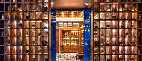 A wooden shelving unit with glass jars, a patterned floor, and a blue accent wall.