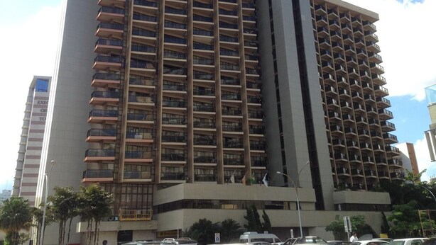 Un hotel de varios pisos con un diseño arquitectónico moderno, que cuenta con numerosos balcones y una estructura vertical destacada.