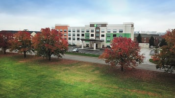 Un hotel Holiday Inn Express con aparcamiento y follaje otoñal.