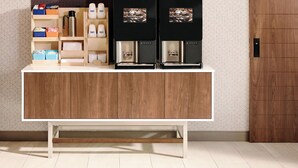 Una kitchenette moderna con un mueble de madera, una cafetera y estanterías.