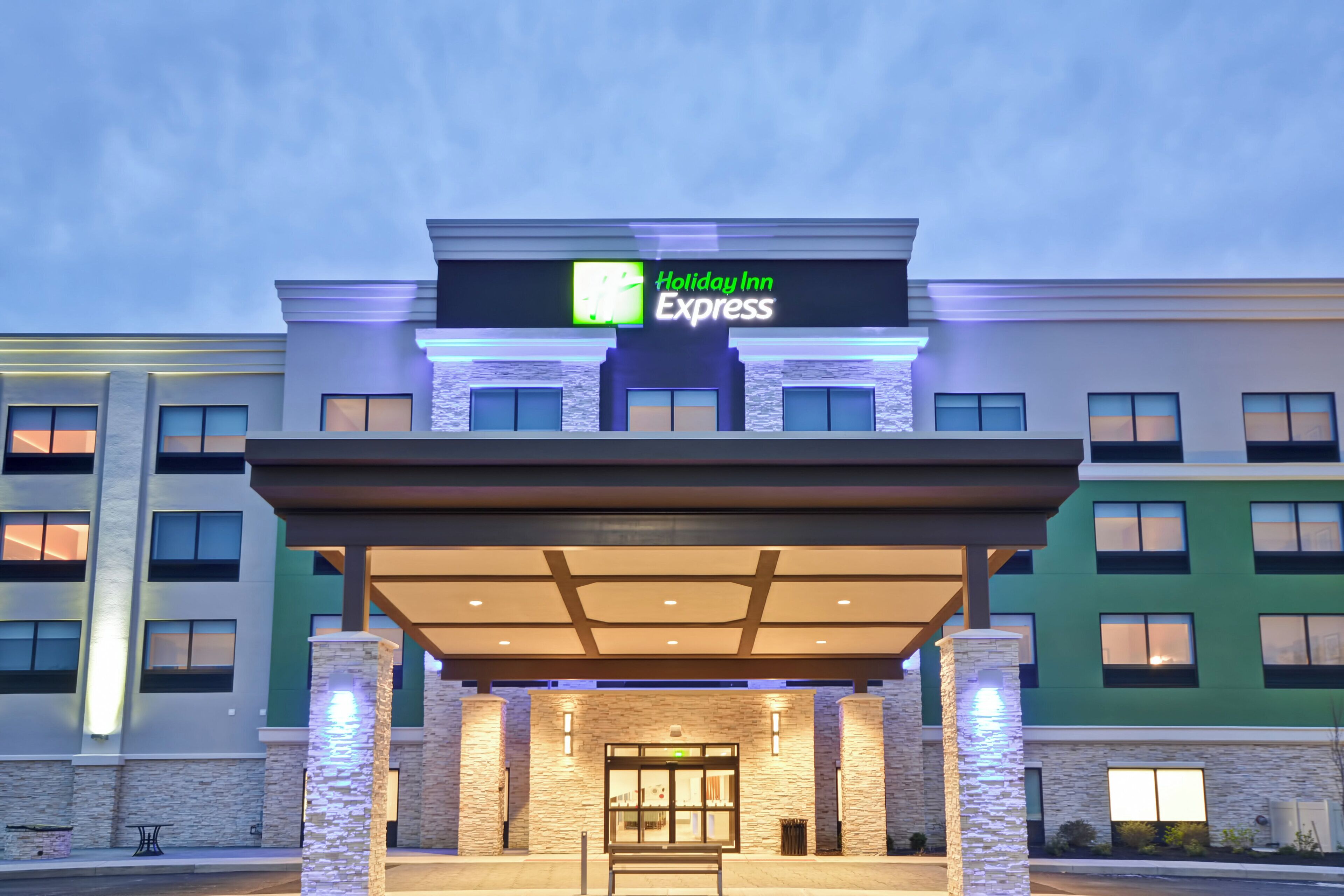 A Holiday Inn Express building with a covered entrance, stone facade, and multiple windows.
