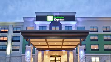 A Holiday Inn Express building with a covered entrance, stone facade, and multiple windows.