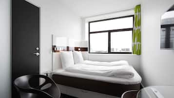 Una habitación de hotel moderna con una cama, un escritorio y una silla.
