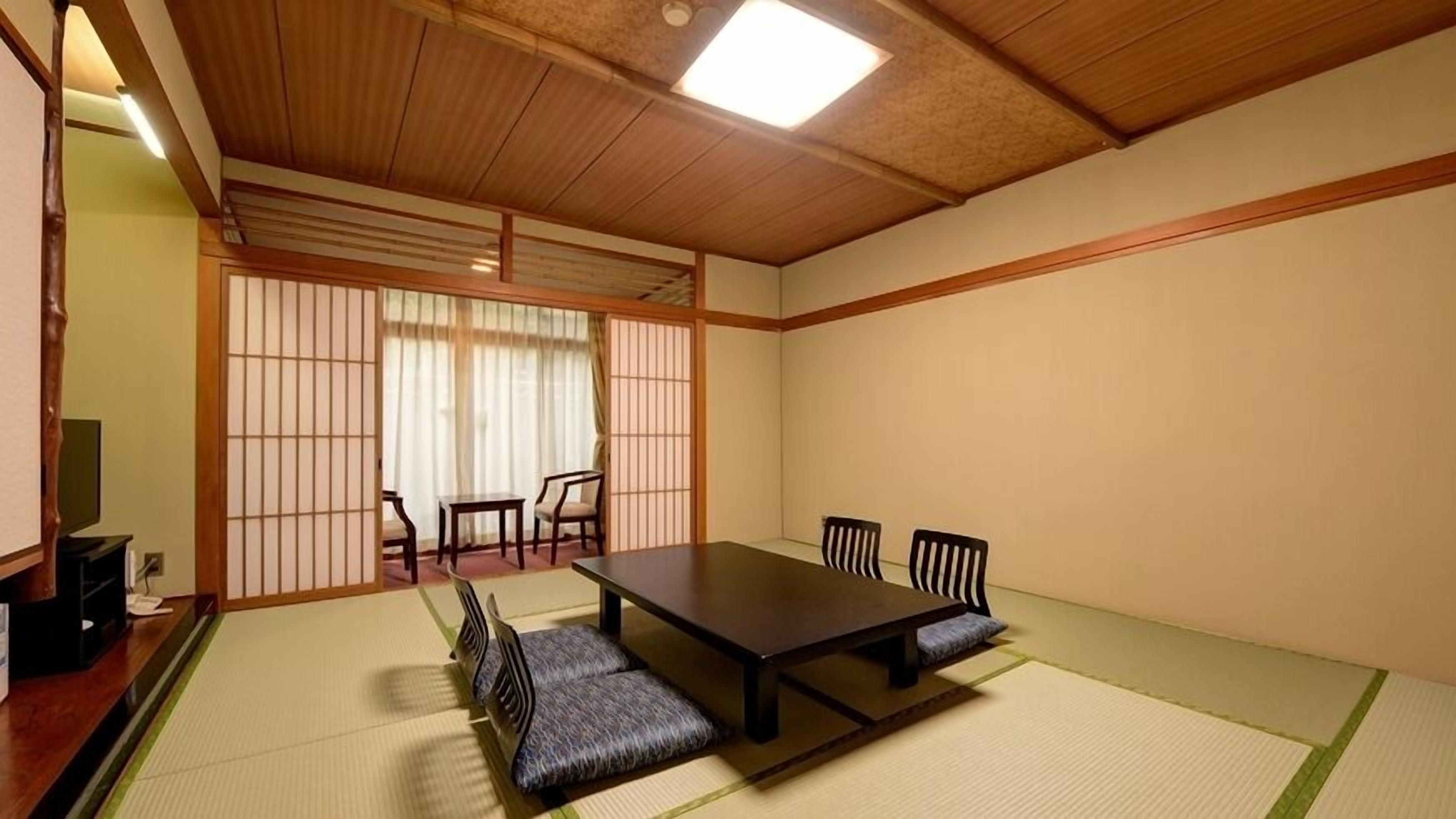 Una habitación japonesa tradicional con suelo de tatami, una mesa de madera baja y puertas correderas shoji.