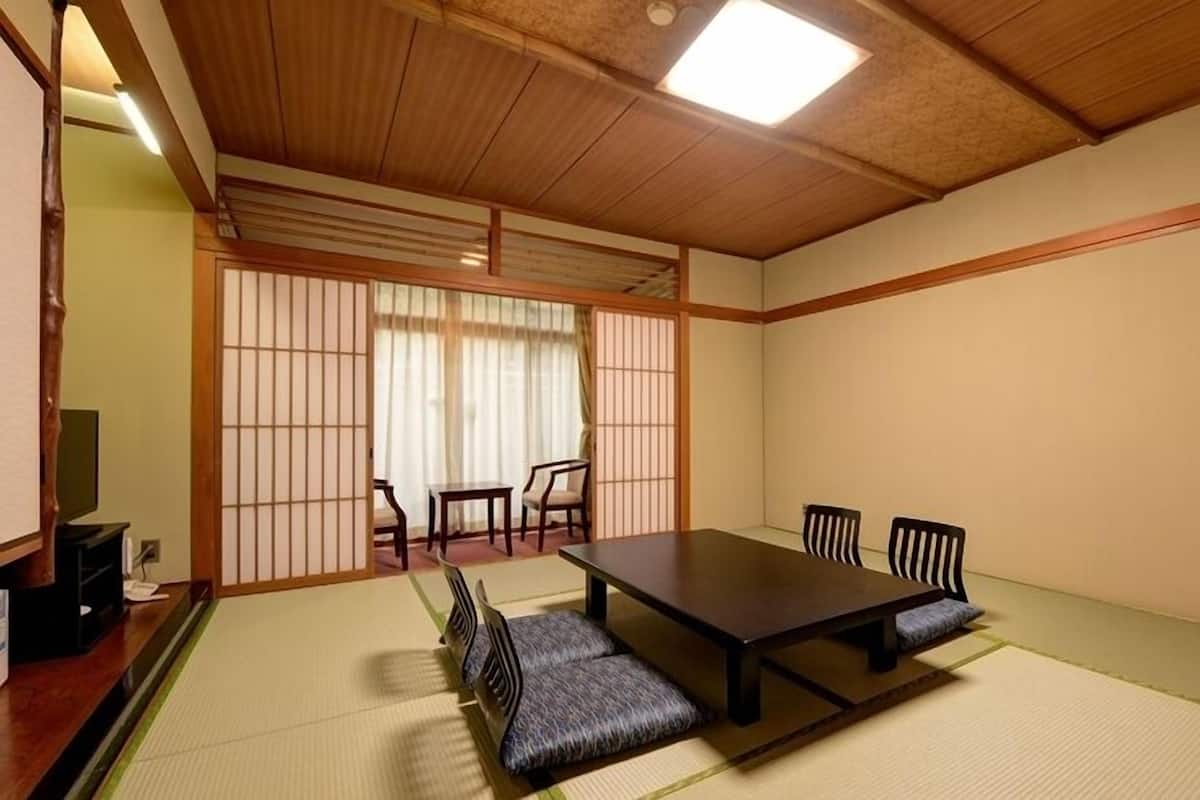 A traditional Japanese room with tatami flooring, a low wooden table, and shoji screens.